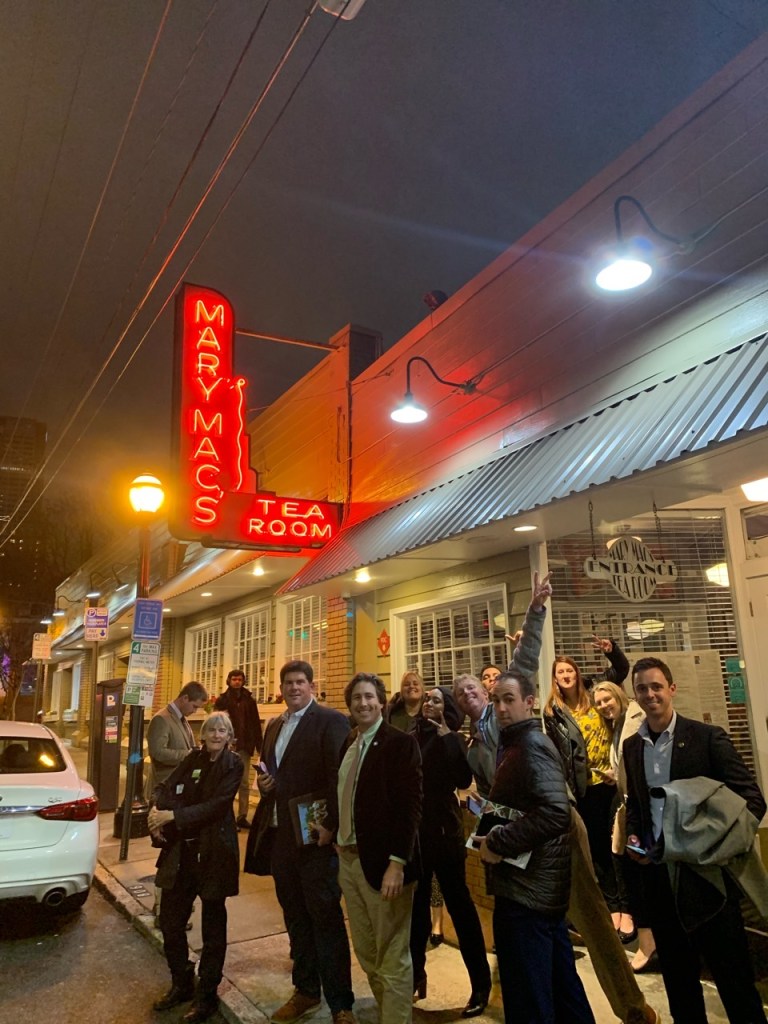 A group of people standing in front of a building

Description automatically generated